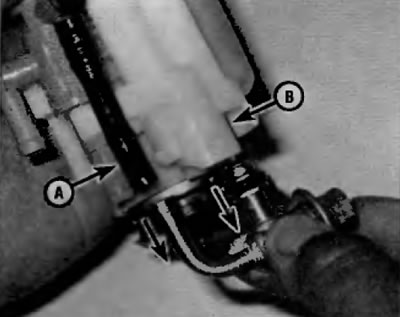 Рис. 6.6. Отсоедините регулятор давления топлива от шланга калиброванного возвратного патрубка (А)…