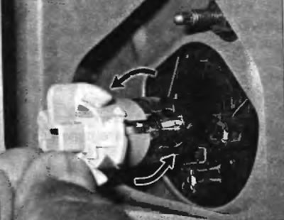 Рис. 19.16. Для снятия лампы заднего фонаря поверните его против часовой стрелки и вытяните из…