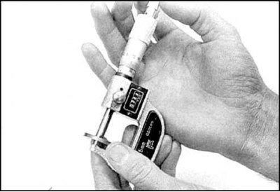 8. Уберите клещи. Удерживая толкатель, достаньте регулировочную шайбу отверткой (фото слева) или…