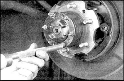 1. Отверните гайки (указаны стрелками) фланца полуоси и снимите шайбы.