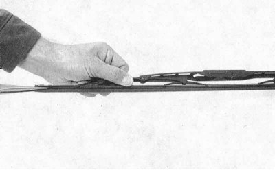 1. Отведите рычаг стеклоочистителя от стекла. Отожмите стопорный язычок, опустите щетку вниз по…