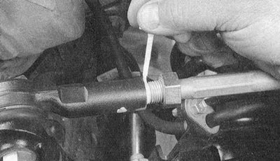 2. Извлеките шплинт и ослабьте, но не отворачивайте до конца корончатую гайку шарового пальца…