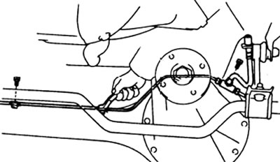б) Отверните болты крепления зажимов и снимите тройник в сборе со шлангом и трубками.
